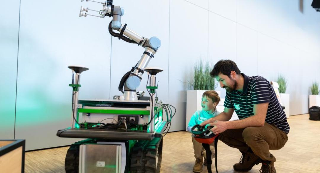 man en kind besturen robotarm